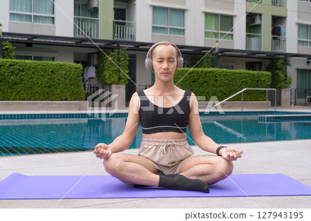 Non-binary person exercising in poolside doing yoga and wearing sport bra Non-binary person exercising in poolside doing yoga and wearing sport bra 127943195