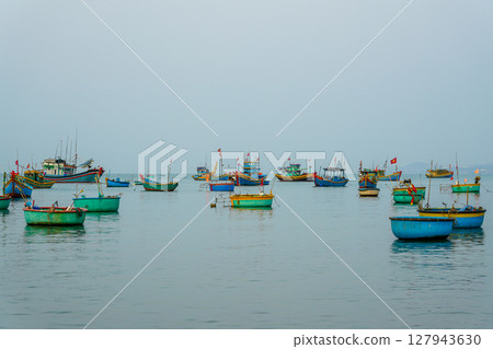 Colorful Traditional Fishing Boats Float Calmly in the Waters of Mui Ne Bay, Vietnam 127943630