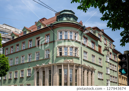 Historic green building with decorative architecture on city street in Europe 127943674