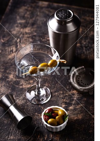 Traditional martini cocktail with olives and Traditional martini cocktail with olives and 127944081