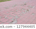 Damaged Red Brick Walkway Needs Immediate Repair 127944405