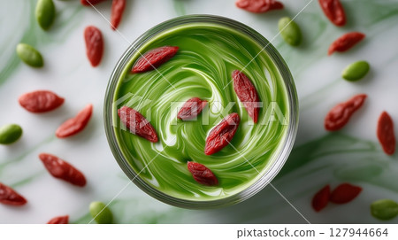 smoothie glass with spirulina and goji berries swirling inside like a magical potion 127944664