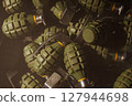 A bunch of metal hand grenades laying in box 127944698