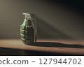 Hand grenade on a dark wooden floor illuminated by ray of the light 127944702