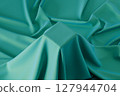 Cubic pedestal covered by green soft fabric 127944704