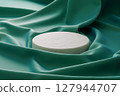 White stone pedestal placed on a green fabric 127944707
