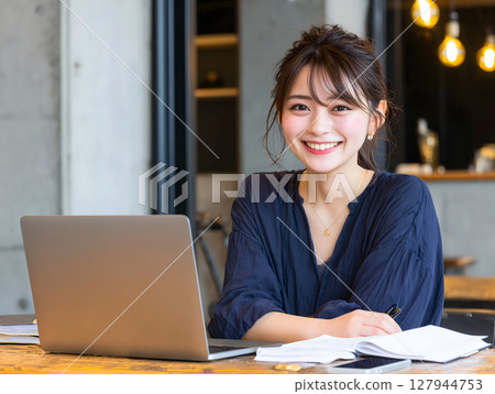 一位美麗的女人在咖啡館裡用筆記型電腦微笑的明亮肖像 一位美麗的女人在咖啡館裡用筆記型電腦微笑的明亮肖像 127944753