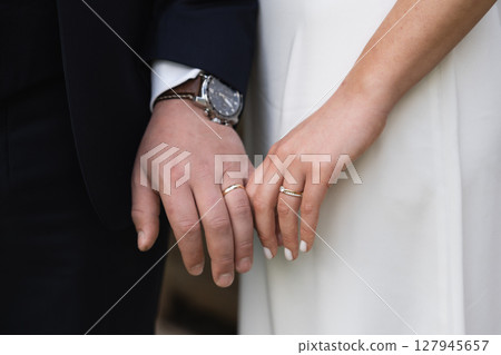 Married couple holding hands with rings ceremony wedding day 127945657