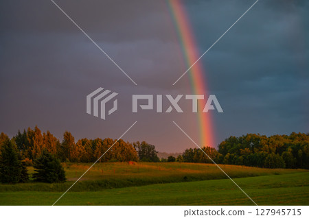 Colorful Rainbow Above Countryside at Golden Hour 127945715