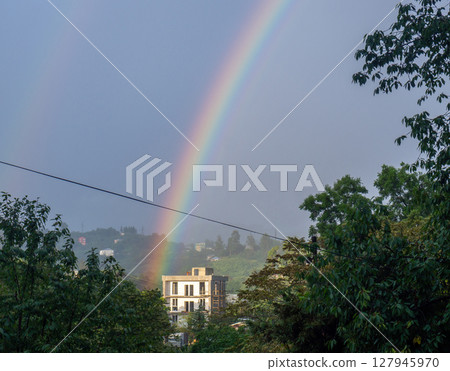 Rainbow in the mountains. Rainbow over a house in the mountains. Beautiful and cozy place. 127945970