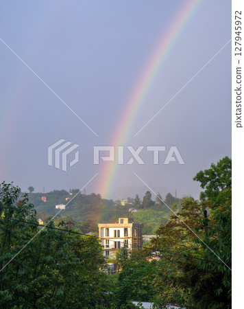 Rainbow in the mountains. Rainbow over a house in the mountains. Beautiful and cozy place. Rainbow in the mountains. Rainbow over a house in the mountains. Beautiful and cozy place. 127945972