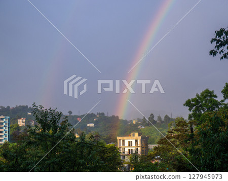 Rainbow in the mountains. Rainbow over a house in the mountains. Beautiful and cozy place. 127945973