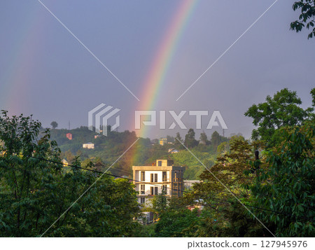 Rainbow in the mountains. Rainbow over a house in the mountains. Beautiful and cozy place. 127945976
