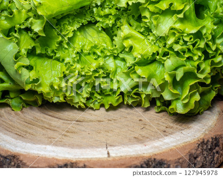 Bunch of lettuce on a wooden tray. Salad concept. Vitamin of natural origin. Leaves up close. Grass background for food. Useful ingredient. Bunch of lettuce on a wooden tray. Salad concept. Vitamin of natural origin. Leaves up close. Grass background for food. Useful ingredient. 127945978