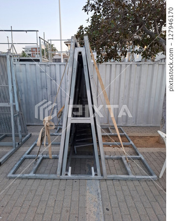 Walls for a bull pen are arranged along a street in a Spanish city in preparation for the running of the bulls festival, showcasing local traditions and excitement. Walls for a bull pen are arranged along a street in a Spanish city in preparation for the running of the bulls festival, showcasing local traditions and excitement. 127946170