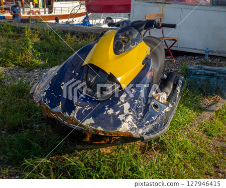Broken jet ski  Abandoned vehicle. Water bike on the shore. 127946415