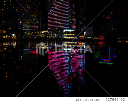 Night city in lights. High-rise buildings at the resort. Restaurants and hotels at night. 127946432