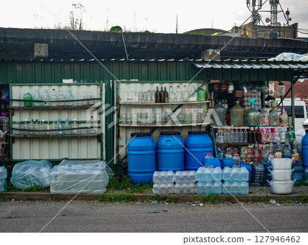 Wholesale market on the street. Lots of different goods. Asian market. Glassware seller. Bottles of different types. private entrepreneurship Wholesale market on the street. Lots of different goods. Asian market. Glassware seller. Bottles of different types. private entrepreneurship 127946462