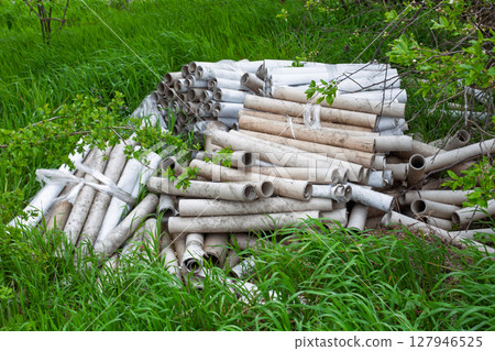 Pile of Abandoned Dirty Construction Tubes in Grass Pile of Abandoned Dirty Construction Tubes in Grass 127946525