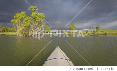 paddling under stormy sky through narrow passage in reeds- POV view from paddling kayak or canoe on Boedecker Reservoir in Loveland, Colorado paddling under stormy sky through narrow passage in reeds- POV view from paddling kayak or canoe on Boedecker Reservoir in Loveland, Colorado 127947510