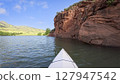 spring kayaking or canoeing along sandstone cliff of Horsetooth Reservoir near Fort Collins, Colorado - POV paddler perspective 127947542