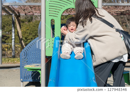 [相模原市麻溝公園兒童遊樂場裡，一名一歲小孩和馬爸爸一起玩耍] 127948346