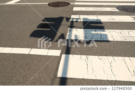 Scenery with the shadow of a pedestrian crossing traffic light 127948500