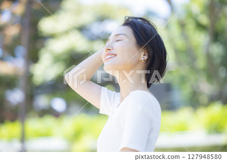 Woman taking a deep breath in the park Woman taking a deep breath in the park 127948580