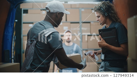 Workers Unloading Cardboard Boxes from Delivery Truck. Female Manager Using Tablet Computer and Scanner Workers Unloading Cardboard Boxes from Delivery Truck. Female Manager Using Tablet Computer and Scanner 127949314