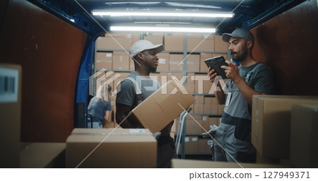 Diverse Employees Unloading Delivery Truck. Manager Scanning Parcels Using Digital Tablet 127949371