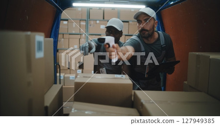 Multiethnic Workers Scanning Cardboard Boxes, Checking Details on Tablet Computer Multiethnic Workers Scanning Cardboard Boxes, Checking Details on Tablet Computer 127949385