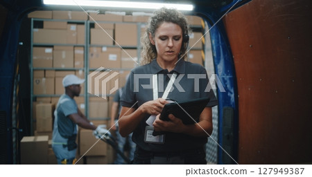 Logistics Warehouse: Female Manager with Digital Tablet Scanning Cardboard Boxes Using Scanner 127949387