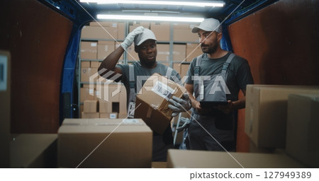 Diverse Employees Unloading Delivery Truck. Manager Scanning Parcels Using Digital Tablet Diverse Employees Unloading Delivery Truck. Manager Scanning Parcels Using Digital Tablet 127949389