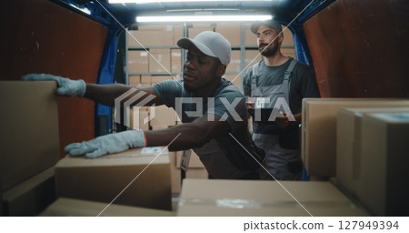 Employees Unloading Delivery Truck with Cardboard Boxes. Manager Using Digital Tablet, Scanning Parcels 127949394