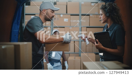 Logistics Distribution Warehouse: Diverse Employees Unloading Delivery Truck with Cardboard Boxes 127949413