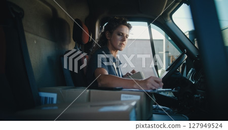 Female Product Supplier Sitting in Truck, Filling Out Papers, Using Digital Tablet 127949524