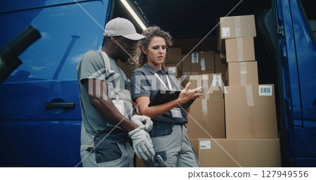 Worker and Female Inventory Specialist Talking, Using Tablet Computer, Standing near Delivery Truck Worker and Female Inventory Specialist Talking, Using Tablet Computer, Standing near Delivery Truck 127949556