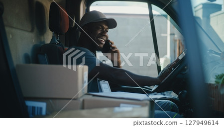 Delivery Truck Driver in Car Talking by Mobile Phone with Customer, Filling Out Papers Delivery Truck Driver in Car Talking by Mobile Phone with Customer, Filling Out Papers 127949614