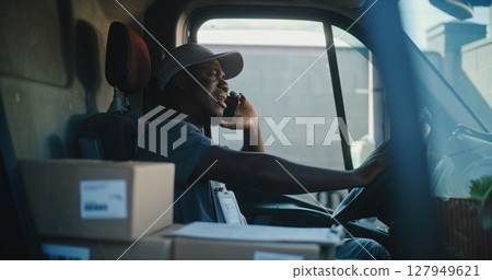 Delivery Truck Driver Sitting in Car, Talking by Mobile Phone with Customer, Delivering Online Orders Delivery Truck Driver Sitting in Car, Talking by Mobile Phone with Customer, Delivering Online Orders 127949621