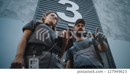 Female Manager Scanning Cardboard Box with Scanner, Using Tablet Computer 127949623