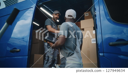 Multiethnic Workers Unloading Cardboard Boxes with E-Commerce Goods from Delivery Truck 127949634