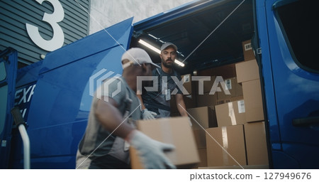 Team of Two Multiethnic Workers Loading Cardboard Boxes in Delivery Truck for Shipping Team of Two Multiethnic Workers Loading Cardboard Boxes in Delivery Truck for Shipping 127949676