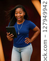 Eccentric African American Woman with Blue T-Shirt and Jeans Holding Digital Tablet and christian pendant rosary 127949942