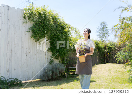 有盆的植物的一名婦女 有盆的植物的一名婦女 127950215