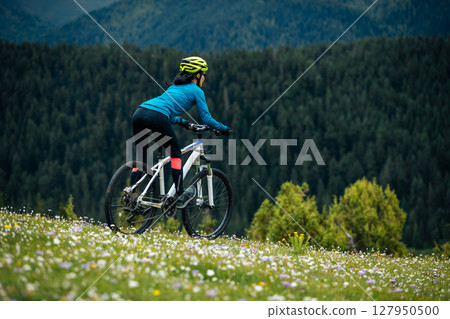 Riding mountain bike on beautiful forest mountain top 127950500