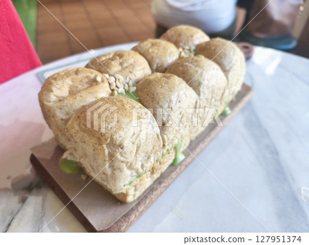 Roti Sarikaya or Indonesian pull apart bread with a vibrant green kaya or coconut jam filling, popular in Southeast Asia. Roti Sarikaya or Indonesian pull apart bread with a vibrant green kaya or coconut jam filling, popular in Southeast Asia. 127951374