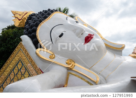 Biggest reclining Buddha situated in Wat Chetawan temple in the downtown of Chiang Rai province of Thailand. 127951993