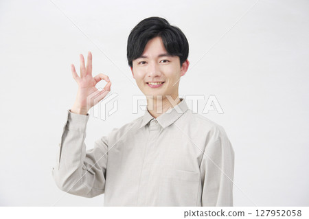 Man in his 20s OK sign white background 127952058