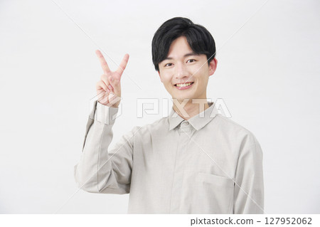 Man in his 20s, peace sign, white background 127952062