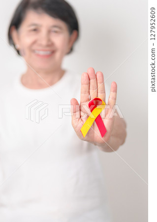 World hepatitis day awareness month, 28 July. elderly woman with Red and Yellow ribbon. Liver cancer, Jaundice, Cirrhosis, Failure, Enlarged, Hepatic Encephalopathy and Health concept World hepatitis day awareness month, 28 July. elderly woman with Red and Yellow ribbon. Liver cancer, Jaundice, Cirrhosis, Failure, Enlarged, Hepatic Encephalopathy and Health concept 127952609
